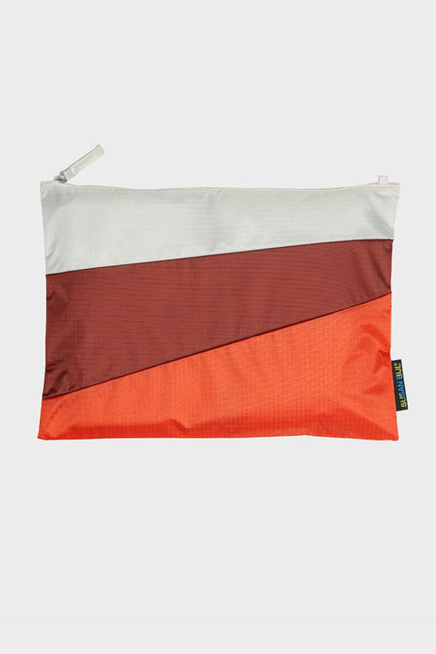 The New Pouch Multi Oxyde Large von Susan Bijl, Vorderseite, drei diagonale Farbflächen in Cremeweiß, Dunkelrot und Orange, weißer YKK-Reißverschluss