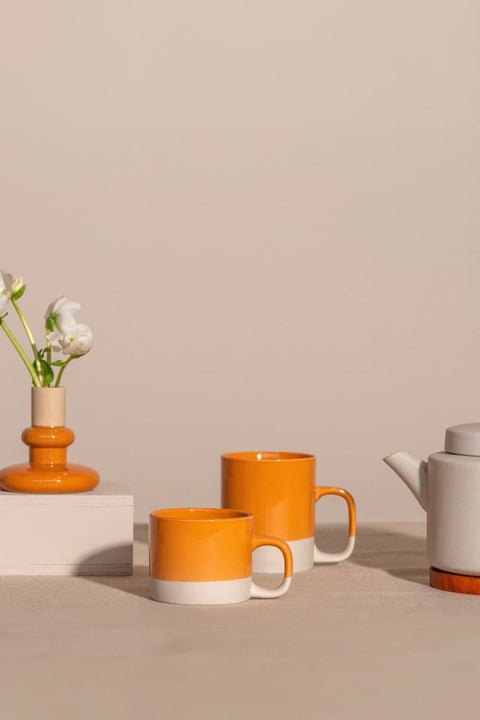 Cyl-Kollektion von KINTA in Orange, mehrere Steinzeug-Produkte – Tassen, Teekanne und Schalen in Apricot
KINTA Cyl Kollektion Orange Apricot, handgefertigtes Steinzeug aus Hanoi, Fair Trade, matt mit glänzenden Akzenten