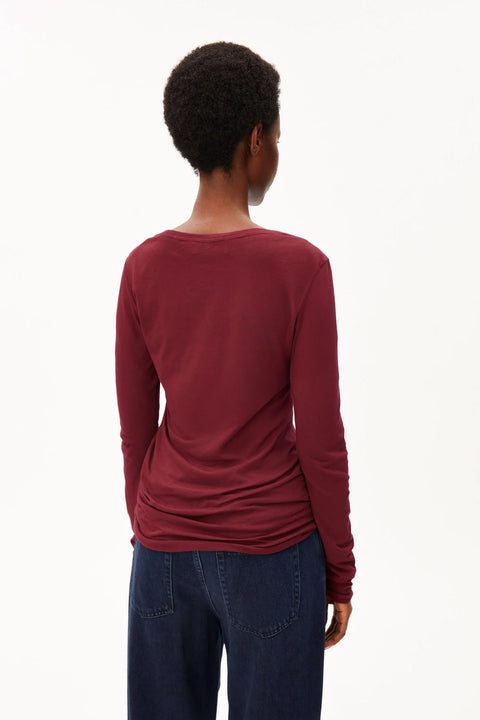 Rückansicht des Einiaara Langarmshirts mit charakteristischer offener Kante am Saum