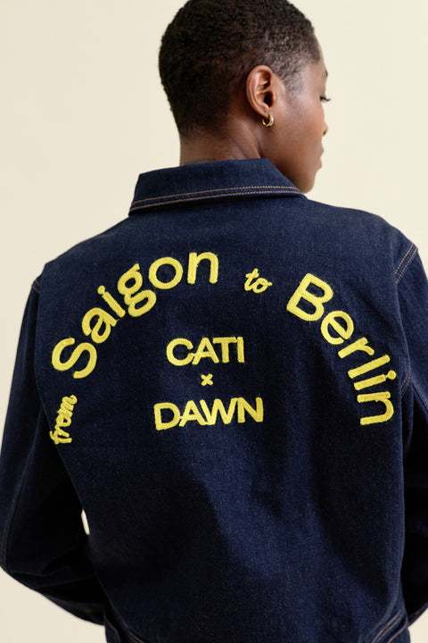 MOTO Biker Jacket DAWN Denim × CATI – Detailansicht gelbe Stickerei auf Stay Blue Denim, geknöpfte Manschetten und Paspeltaschen