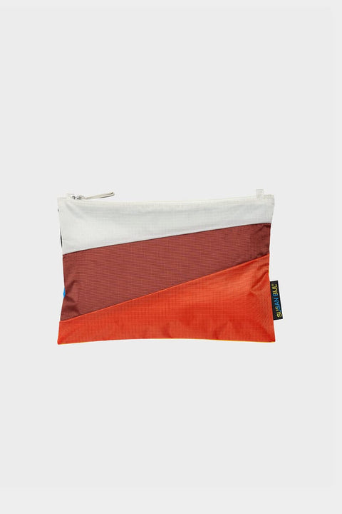 The New Pouch Multi Oxyde Medium von Susan Bijl, Vorderseite, diagonale Farbflächen in Cremeweiß, Dunkelrot und Orange, weißer YKK-Reißverschluss