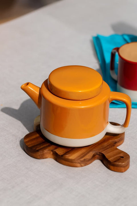 Teekanne Cyl L KINTA Apricot, auf Tisch serviert mit passenden Cyl-Tassen in Orange, Fair Trade Kollektion
