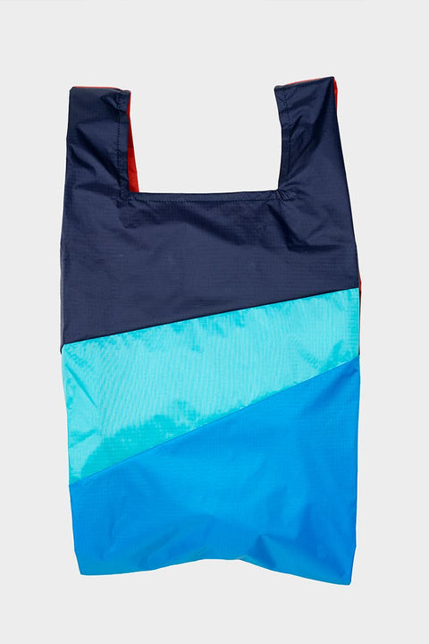 The New Shopping Bag Multi Drive Large von Susan Bijl, Vorderseite, drei diagonale Farbflächen in Navy, Türkis und leuchtendem Blau