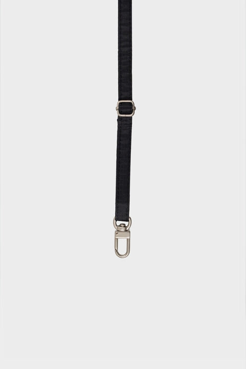 New Strap in schwarz an einer New Pouch befestigt, die als Umhängetasche getragen wird