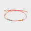 Armband "Sweet String – White Season" von Blush Indigo, getragen an einem Handgelenk, lebendige Farben