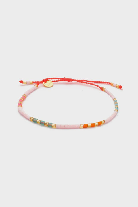 Armband "Sweet String – White Season" von Blush Indigo, getragen an einem Handgelenk, lebendige Farben