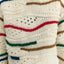 Cremefarbener Pullover mit bunten Details und breiten Bündchen