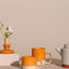Cyl-Kollektion von KINTA in Orange, mehrere Steinzeug-Produkte – Tassen, Teekanne und Schalen in Apricot
KINTA Cyl Kollektion Orange Apricot, handgefertigtes Steinzeug aus Hanoi, Fair Trade, matt mit glänzenden Akzenten