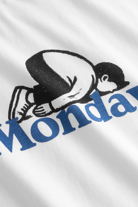 Stockholm Monday Crash Dedicated – Detailansicht kauernde Figur in Schwarz über fettem Monday-Schriftzug in Blau auf weißem Shirt