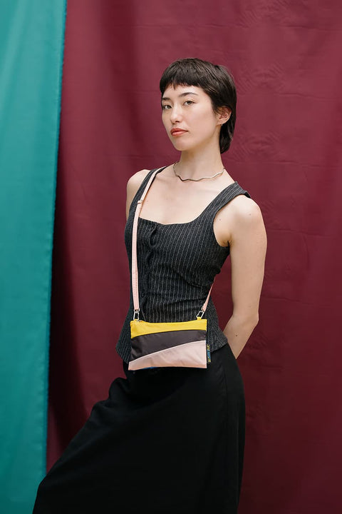 The New Pouch Multi Black Small von Susan Bijl, Vorderseite, diagonale Farbflächen in Gelb, Schwarz und Zartrosa, gelber YKK-Reißverschluss
