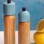 MÆGEN Salz- und Pfeffermühle Sky Blue Burgundy, auf gedecktem Tisch in Hellblau und Rot