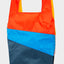 The New Shopping Bag Multi Tone Large Susan Bijl, Rückseite, diagonale Farbflächen in leuchtendem Orange, Blau und Dunkelgrau