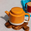 Teekanne Cyl L KINTA Apricot, auf Tisch serviert mit passenden Cyl-Tassen in Orange, Fair Trade Kollektion