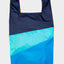 The New Shopping Bag Multi Drive Large von Susan Bijl, Vorderseite, drei diagonale Farbflächen in Navy, Türkis und leuchtendem Blau